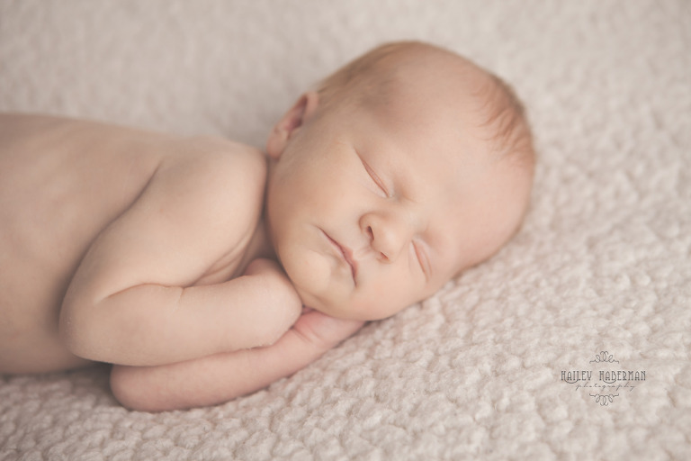 Ellensburg Newborn Photographer captures Baby Boy Ryle  cuddled on side 