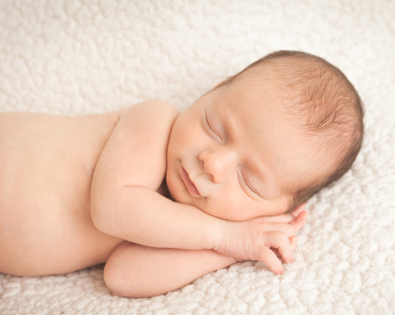 10 day old Newborn Baby Boy sleeping on hands in natural pose