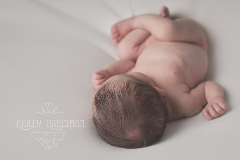 newborn baby girl asleep in natural pose with close up of top of head