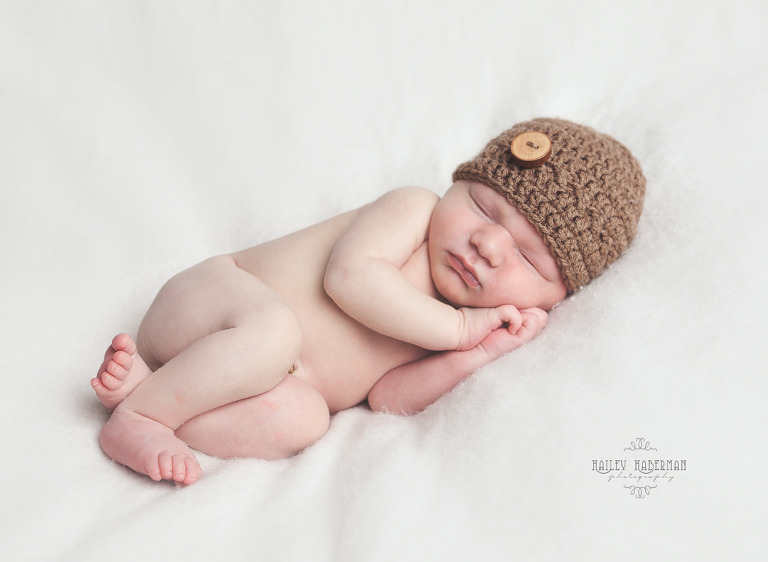 Newborn Baby Cayson asleep on neutral blanked in handmade knit hat